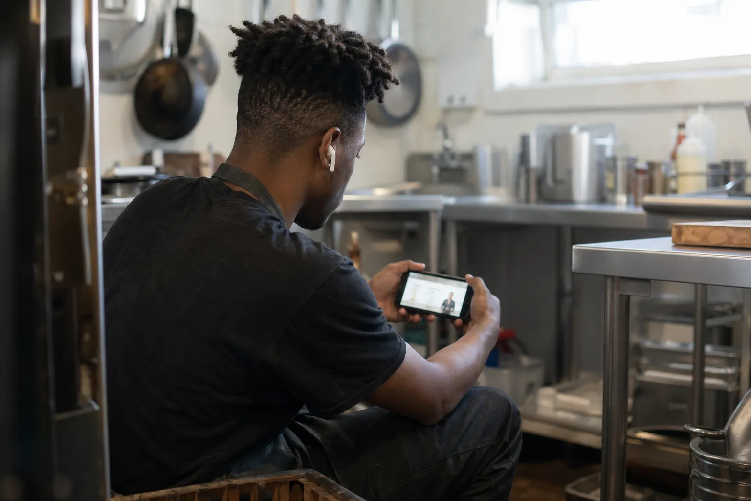 A line cook taking a break to study a CertReady module on his phone